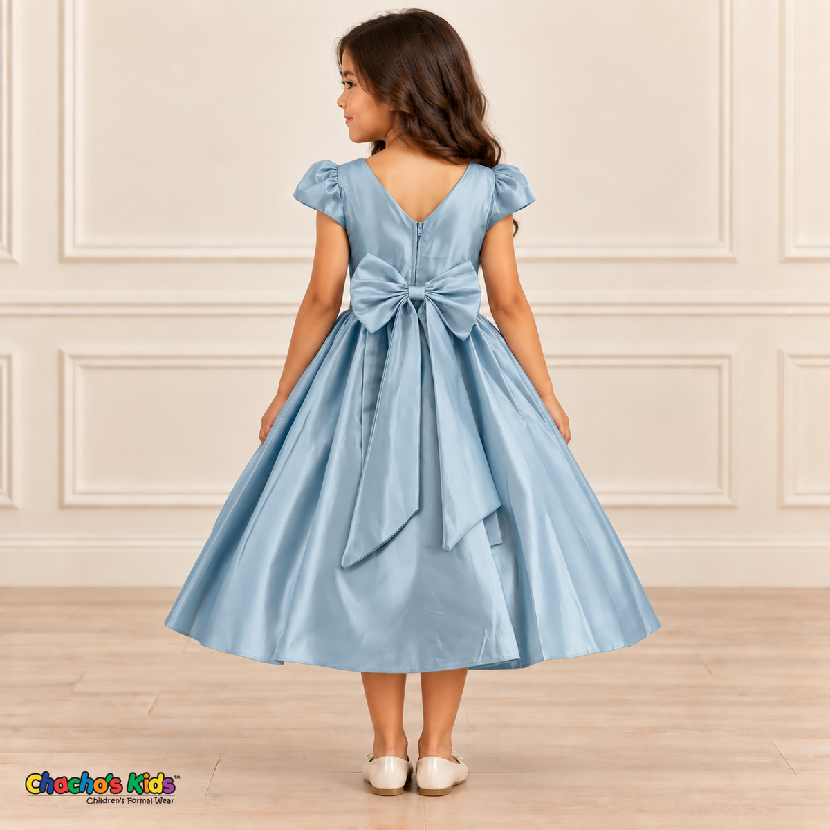 Back view of a girl wearing a pale light-blue satin party dress with a V-shaped neckline, zipper and large matching bow.