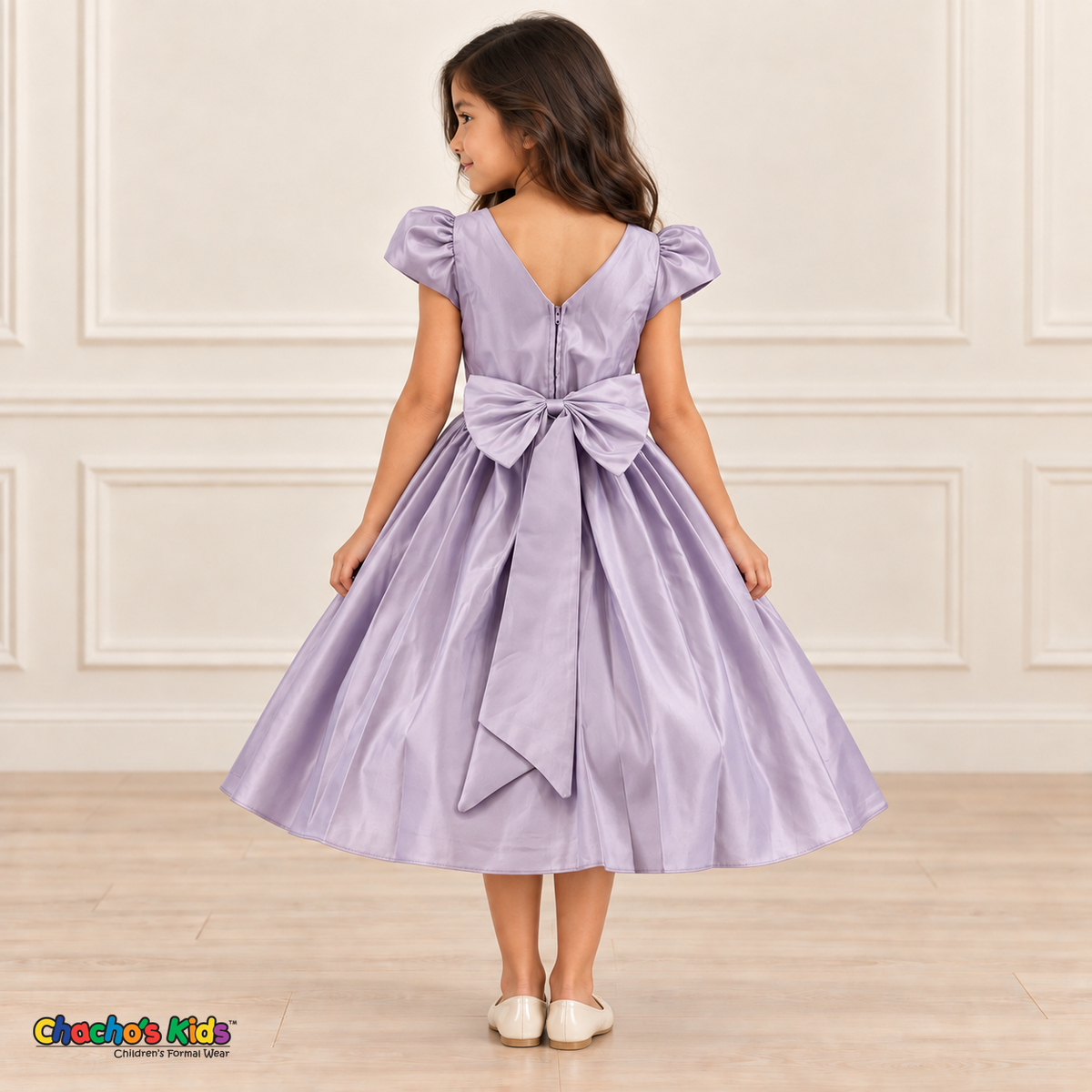 Back view of a girl wearing a lilac satin party dress with a V-shaped neckline, zipper and large matching bow.