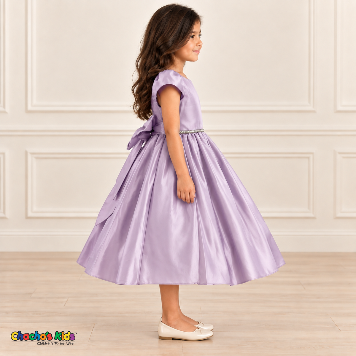Side view of a girl wearing a lilac satin party dress with short puff sleeves, a jeweled waist and a full skirt.
