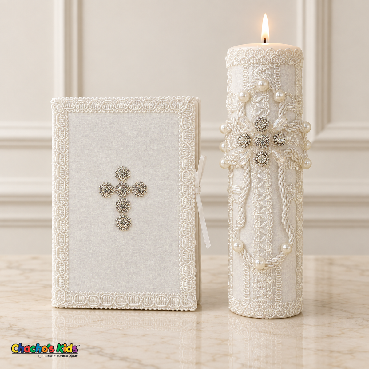 Lit ivory and white baptism candle with pearl and crystal cross beside a Bible with a silver-tone crystal cross.
