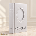 Small white English Holy Bible with silver floral decoration and an empty front portrait window.