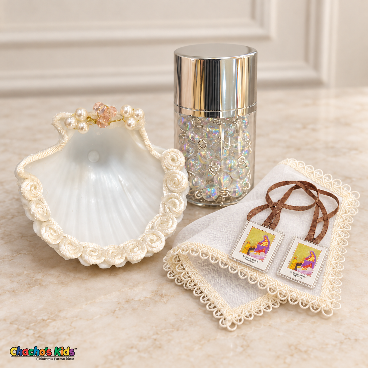 Baptism shell with ivory rosette edging, iridescent rosary in a silver-lidded jar, ivory handkerchief, and brown-ribbon devotional scapular.