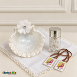 White floral baptism shell, white handkerchief, rosary in a silver-lidded jar and unpackaged brown-ribbon scapular.
