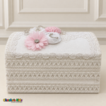 Closed white lace-covered baptism keepsake chest with a rounded lid, pale pink and white flowers, pearl-like accents, and sparkling trim.