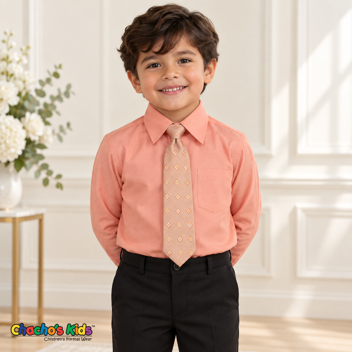 Boy wearing a classic coral long-sleeve dress shirt with its coordinating patterned tie and black dress pants