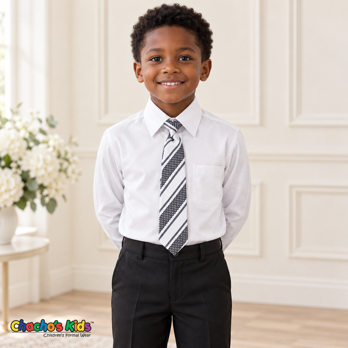 Boy wearing a classic white long-sleeve dress shirt with its coordinating patterned tie and black dress pants
