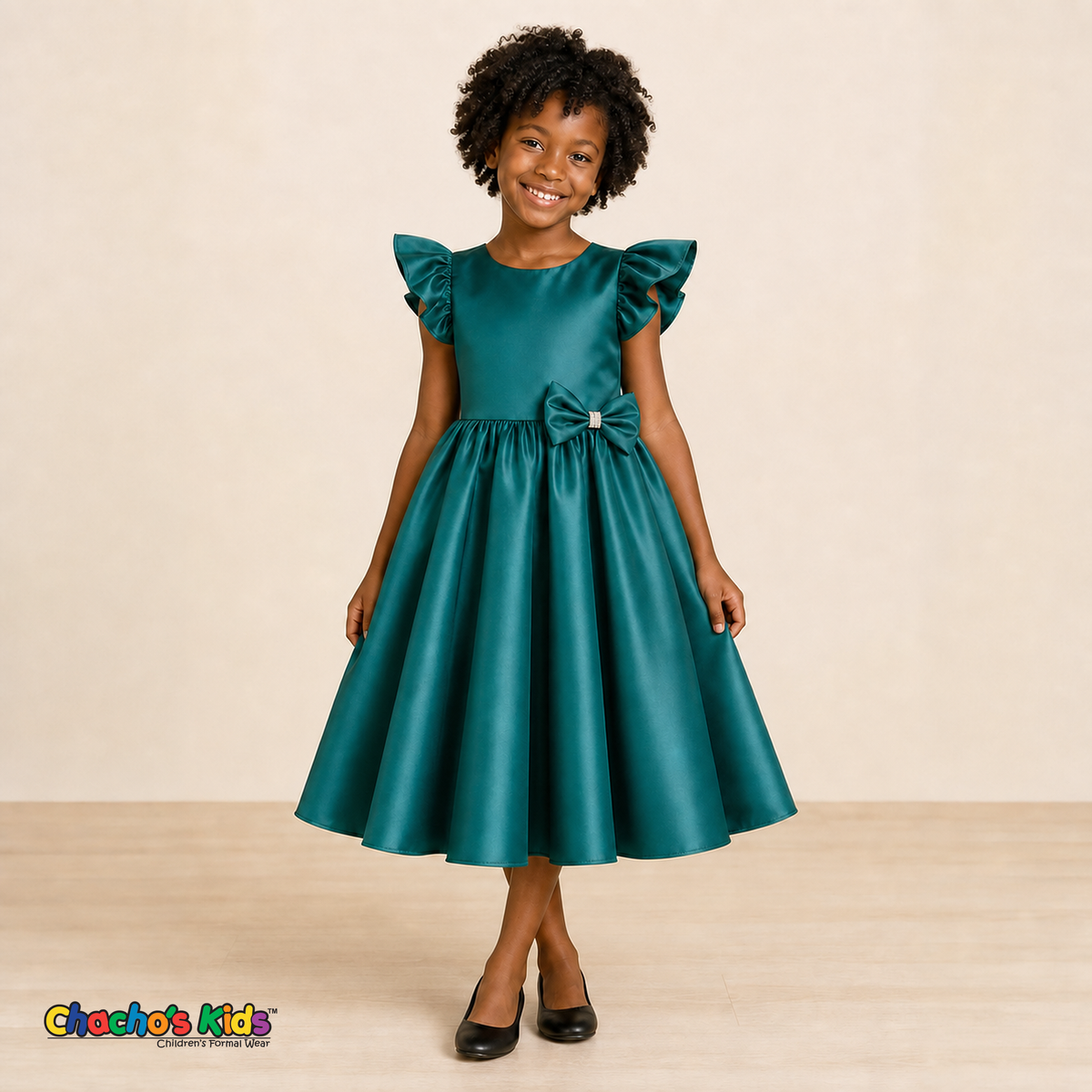 Girl wearing emerald green satin flower girl dress with bow, flutter sleeves and full skirt