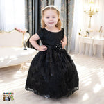 Girl wearing black embroidered flower girl dress with satin bow, cap sleeves and full tulle skirt