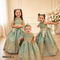 Three girls wearing Sophie sage green gold lace tulle dresses in an elegant formal setting